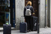 Una mujer accede a un portal de un apartamento turístico.-BERNARDO DÍAZ