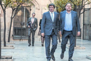 Carles Puigdemont y Oriol Junqueras caminan por el Pati dels Tarongers del Palau de la Generalitat, antes de una reunión de Govern.-FERRAN SENDRA