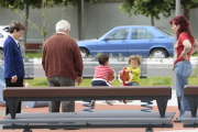 Dos menores juegan en un parque de la ciudad ante la mirada de tres personas mayores.-ISRAEL L. MURILLO