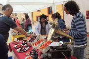 Varias personas rodean un bien decorado puesto de cerezas, ayer en Salas.-G. G.