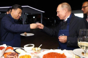 El presidente ruso, Vladimir Putin, brinda con su homólogo chino, Xi Jinping, en una feria alementaria en Vladivostok.-AFP / SERGEI BOBYLYOV