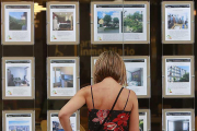 Una mujer observa los anuncios en el escaparate de una agencia.-R. OCHOA