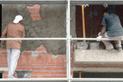 Dos obreros cubren una fachada.-ISRAEL L. MURILLO