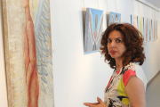 Belén de la Parte, junto a algunas de las pinturas realizadas con pigmentos naturales que visten el Espacio de Arte Ural Motor.-Israel L. Murillo