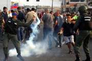 Un militar lanza un bote de gas lacrimógeno durante los disturbios en Caracas-CARLOS GARCIA RAWLINS (REUTERS)
