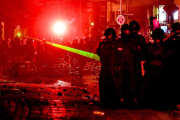 Los manifestantes usan un láser contra la policía.-EFE