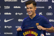 Philippe Coutinho sostiene la camiseta con su nombre durante el acto de presentación.-JORDI COTRINA