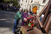 Tres asistentes depositan un ramo de flores rojas junto al monumento del Heptacordo.-SANTI OTERO