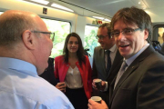 El 'president' Carles Puigdemont y la jefa de la oposición, Inés Arrimadas, junto al 'conseller' Josep Rull, en el Euromed Barcelona-Valencia.-EL PERIÓDICO