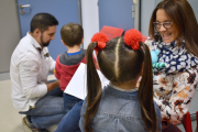 Una pareja recibe a dos niños de acogida con unos juguetes. ECB