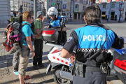 Dos agentes motorizados atienden a unos turistas en el acceso peatonal al Paseo del Espolón.-ISRAEL L. MURILLO