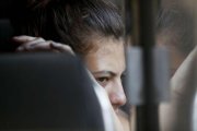 Una migrante hondurena mira por la ventana del autobus que la regresara voluntariamente a Honduras desde Tecun Uman, Guatemala.-EFE / ESTEBAN BIBA