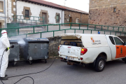 Un operario de la Junta desinfectando contenedores de basura en Quintanar. ECB