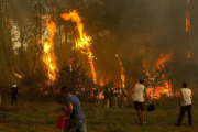 Un grupo de vecinos trabaja en el incendio en la zona de Zamanes, cerca de Vigo.-EFE / SALVADOR SAS