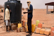 Dos refugiados recogen agua en un tanque en un campo de Níger.-ESMA CAKIR