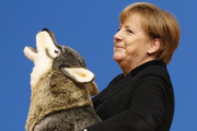 Angela Merkel, con un lobo de peluche con el que ha sido obsequiado en la convención de la CDU en Karlsruhe, este lunes.-AP / MICHAEL PROBST