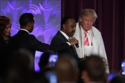 Donald Trump con una túnica de oración durante la visita a una iglesia negra en Detroit.-EVAN VUCCI / AP