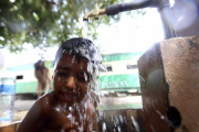 Un niño se refresca en un caluroso día en Karachi, Pakistán.-Foto: EFE / REHAN KHAN