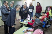 El subdelgado, el delegado territorial y mandos policiales saludan a los niños en una clase.-ISRAEL L. MURILLO