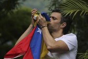 Leopoldo López besa la bandera venezolana tras ser liberado.-AP / ARIANA CUBILLOS