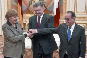 Merkel y Hollande, con el presidente ucraniano, Petró Poroshenko (en el centro), justo antes del inicio de la reunión, ayer, en Kiev.-Foto: REUTERS