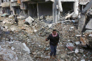 Hombres kurdos caminan entre los escombros en la parte norte de Kobani.-Foto: REUTERS / OSMAN ORSAL
