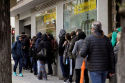 Decenas de personas hacen cola en una oficina de Correos para votar en las elecciones generales.-CARLOS PÉREZ (EFE)