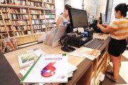 Una mujer atiende a otra en una librería de la capital burgalesa.-ISRAEL L. MURILLO
