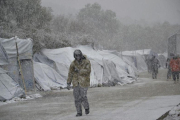 Varios refugiados caminan bajo la nieve en el campamento de refugiados de Moria en la isla de Lesbos, Grecia.-EFE / STRATIS BALASKAS