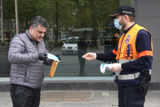 Un voluntario de Protección Civil reparte una mascarilla a un vecino. POLICÍA LOCAL