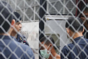 Agentes de policia tailandeses custodian la llegada de un sospechoso de trata de personas en el tribunal penal de Bangkok este miércoles-NARONG SANGNAK