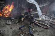 Un hombre sirio portando el cuerpo sin vida de un niño asesinado durante los bombardeos efectuados en la ciudad de Douma,  Siria.-ABD DOUMANY
