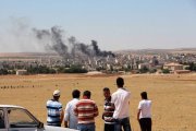 Gente mira el humo de los combates en Kobane desde la frontera turca.-Foto: AFP / STRINGER
