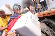 Venzolanos con cajas de ayuda humanitaria que entró por la fontera con Colombia.-EFE