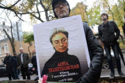 Un hombre sostiene una foto de Politkóvskaya en una concentración en su recuerdo el viernes en Moscú.-AFP / NATALIA KOLESNIKOVA