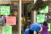 Una mujer pasea frente al escaparate de un comercio.-RAÚL G. OCHOA