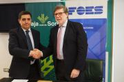 El presidente de Caja Rural de Soria, Carlos Martínez (I) y el presidente de FOES, Santiago Aparicio, firman un convenio contra la despoblación.-ICAL