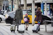 Unos turistas se dirigen a una parada de taxis en Barcelona.-FERRAN NADEU