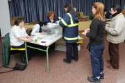 Una empleada de Correos deposita los votos por correo en una de las mesas electorales.-ISRAEL L. MURILLO