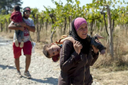 Una mujer carga con su hijo en Macedonia, este viernes.-AFP/ROBERT ATANASOVSKI