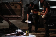 Un cadáver junto a un vehículo acribilladoen Manila.-EFE / EZRA ACAYAN