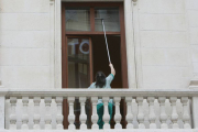 Una trabajadora limpia las ventanas de un edificio.-RAÚL OCHOA