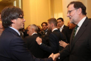 El 'president' Puigdemont saluda a Rajoy durante una inauguración de una exposición sobre Joan Miró en Oporto (Portugal).-JORDI BEDMAR