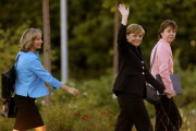 Angela Merkel, custodiada por Beate Baumann (derecha) y Eva Christiansen, a la llegada de la cancillera a un estudio de TV de Berlín.-REUTERS / ARND WIEGMANN