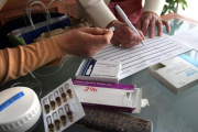Dos enfermeras preparando los medicamentos para muerte digna en casa de un paciente.-MARC VILA