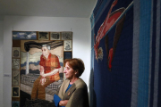 Mayra Alpízar posa junto a un retrato de su padre y ‘El salto’, un bordado de su trabajo feminista.-Raúl Ochoa