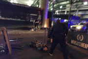 Los tres sospechosos del ataque yacen en el suelo tras ser tiroteados por la policía, ayer, en Londres.-AP / GABRIELE SCIOTTO