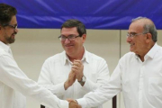 A la izquierda, el líder del equipo negociador de las FARC, Iván Márquez, se da la mano en La Habana con el representante gubernamental, Humberto de la Calle.-ALEXANDRE MENEGHINI / REUTERS