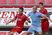 Javi Hervás pugna por un balón con un centrocampista del Numancia en el duelo de ayer en Los Pajaritos-LALIGA.ES