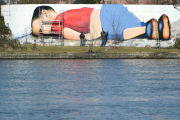 Enorme grafiti de Aylán en la orilla del río que cruza Fráncfort.-AFP / ARNE DEDERT